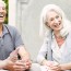 Senior couples playing cards on patio